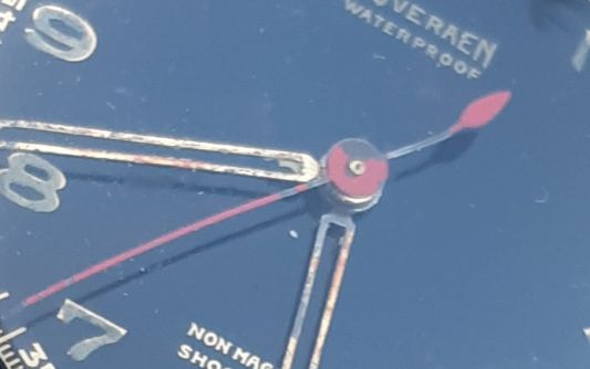 secondewijzer met krom staartje en afbladderende rode verf